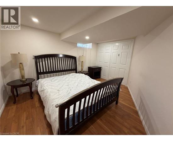 A bedroom with a large bed and a wooden floor.