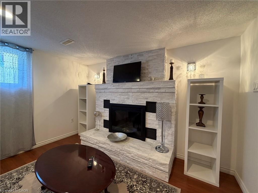A living room with a fireplace and a television above it.