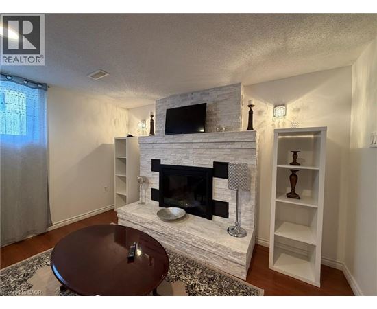 A living room with a fireplace and a television above it.