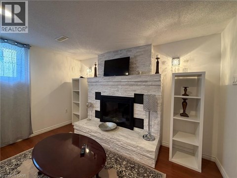 A living room with a fireplace and a television above it.