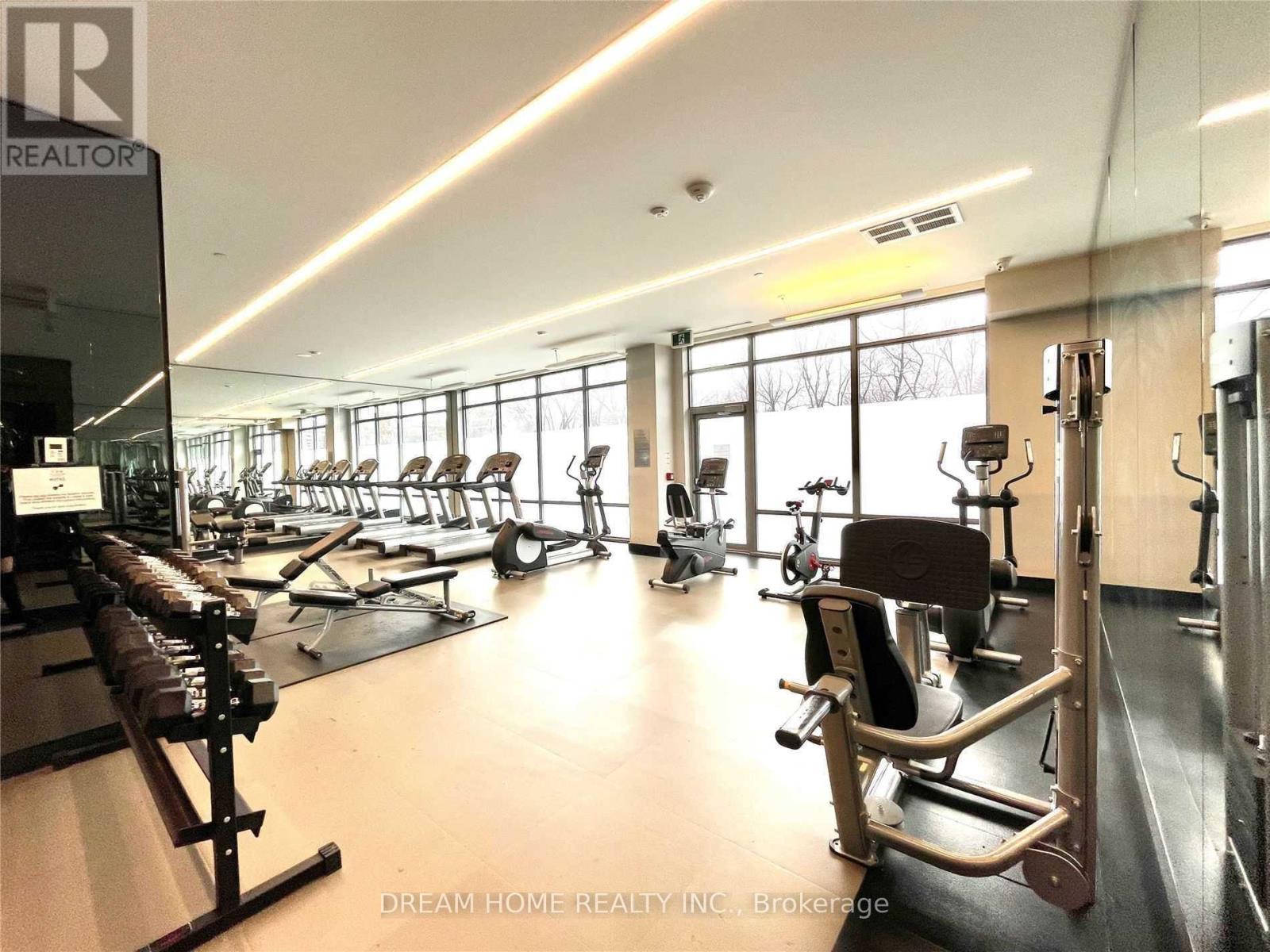 A gym with a variety of equipment including treadmills, weights, and exercise machines.