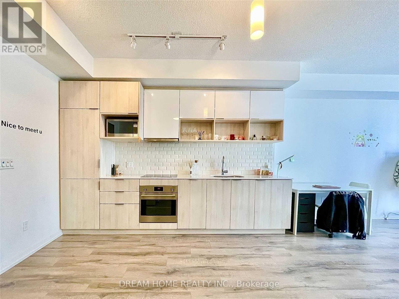 A kitchen with wooden cabinets and a white backsplash.