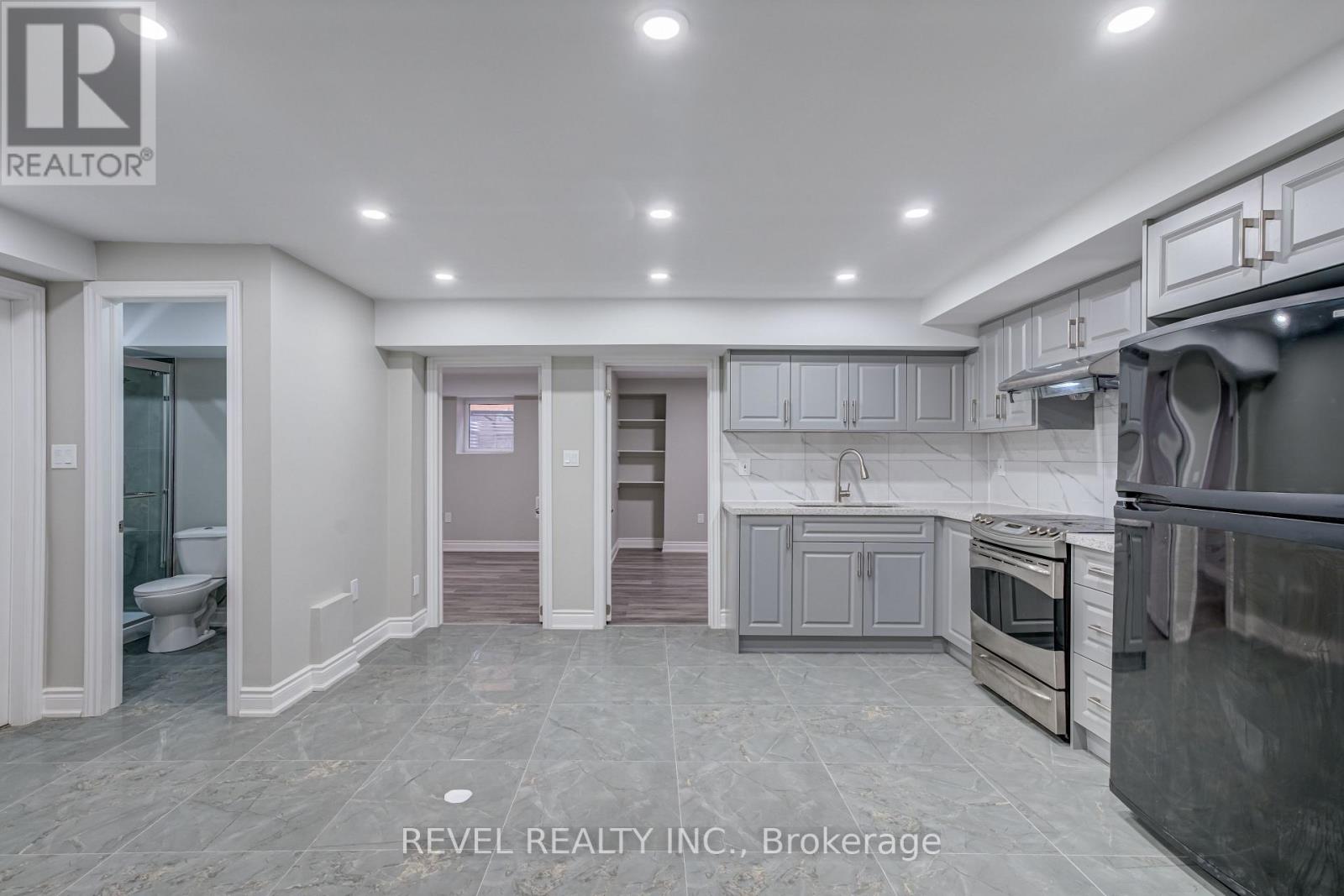 A modern kitchen with grey cabinets and stainless steel appliances.