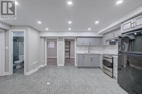 A modern kitchen with grey cabinets and stainless steel appliances.
