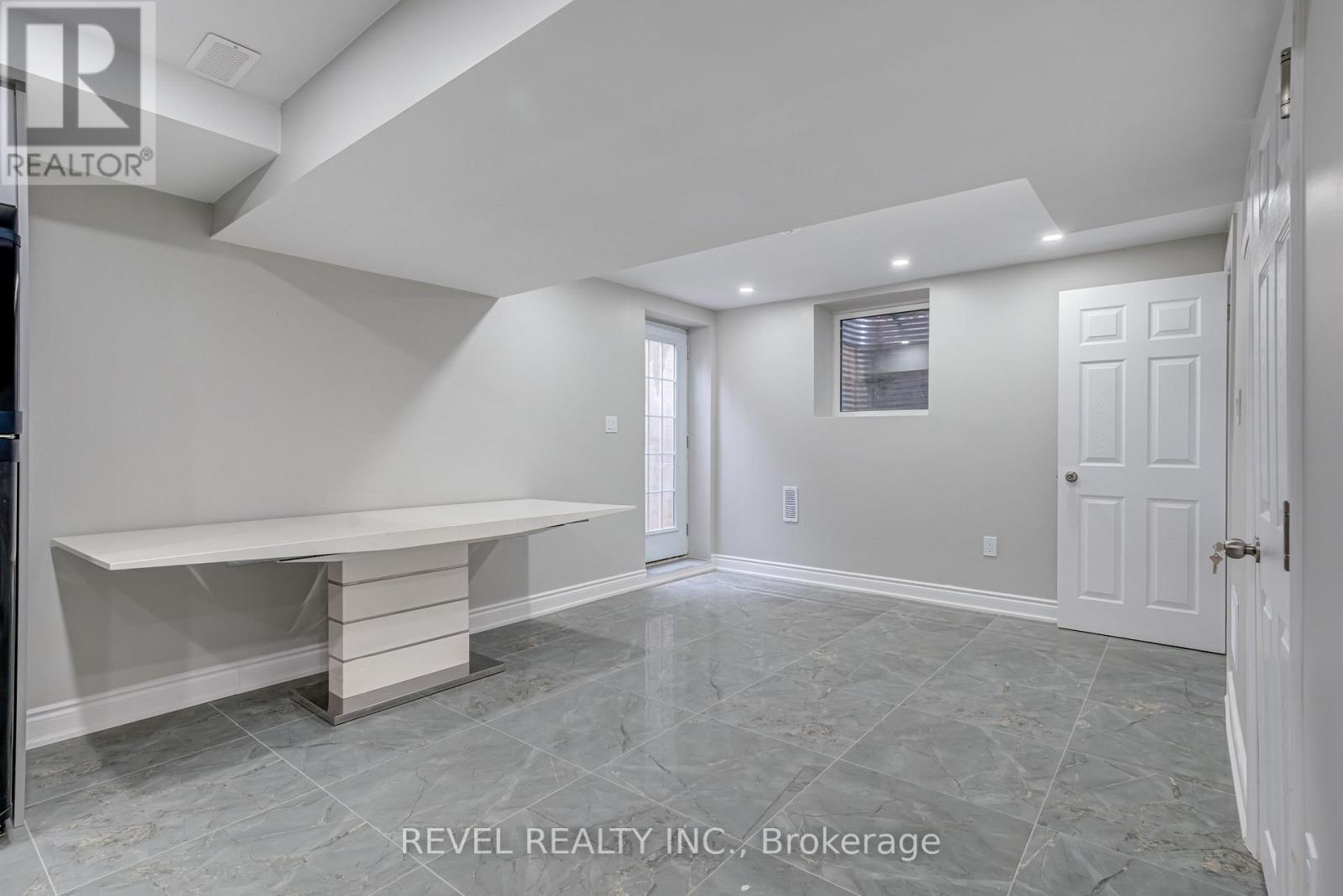 A spacious room with a marble floor and a bench.