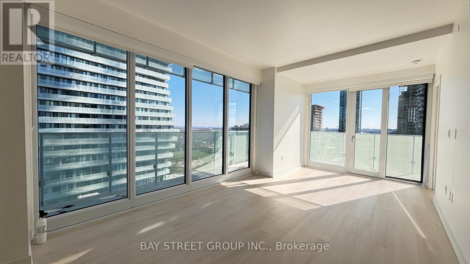 A spacious room with large windows overlooking a cityscape.