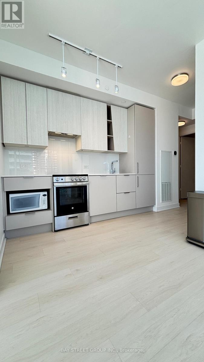 A modern kitchen with white cabinets and stainless steel appliances.
