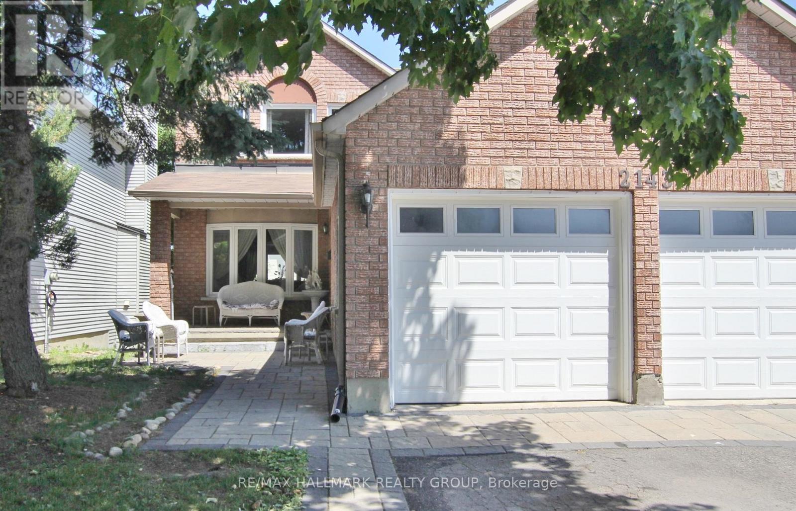 A house with a white garage door and a brick wall.