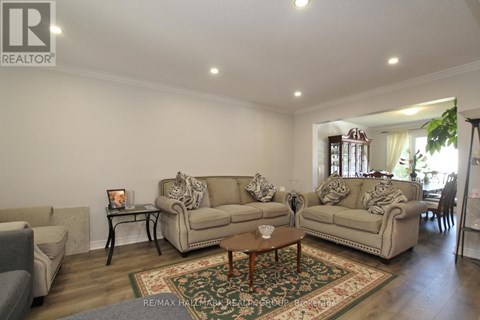 A living room with a rug and a coffee table in the middle.