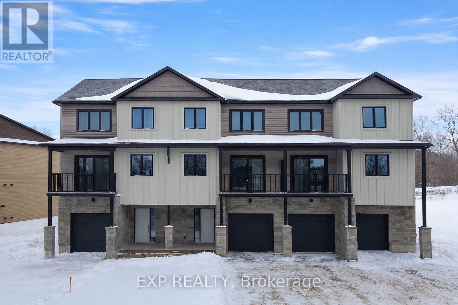 A large, modern house with a balcony and multiple garages is for sale.