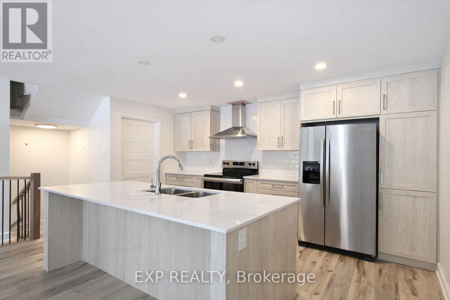 A modern kitchen with a stainless steel refrigerator and a center island.