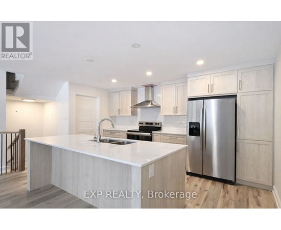 A modern kitchen with a stainless steel refrigerator and a center island.