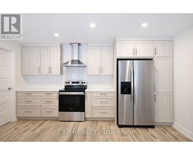 A kitchen with white cabinets and a stainless steel refrigerator.
