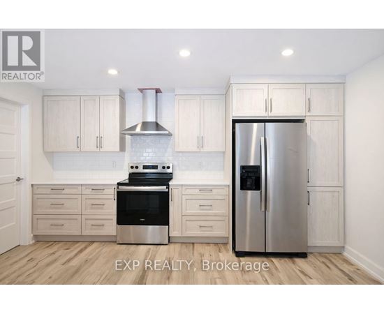 A kitchen with white cabinets and a stainless steel refrigerator.