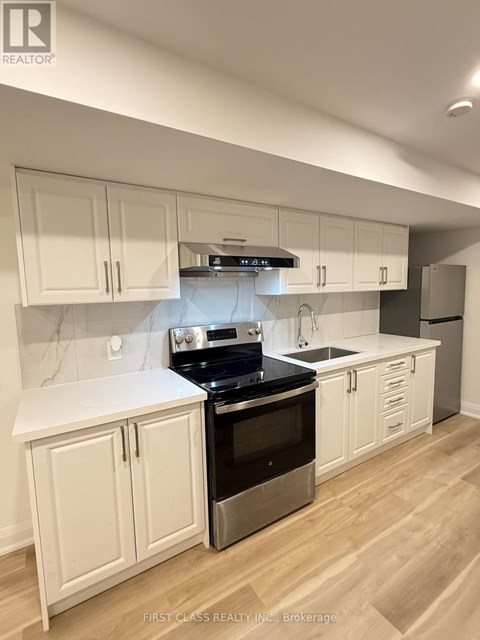 A kitchen with white cabinets and a stainless steel oven.