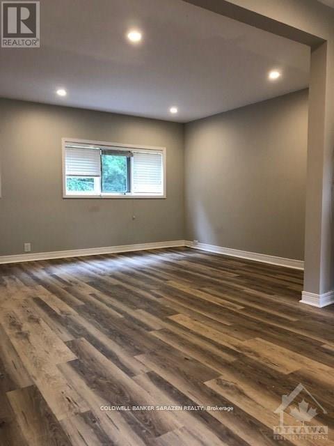 A room with wooden flooring and a window.