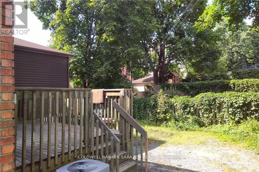A backyard with a wooden deck and a hot tub.