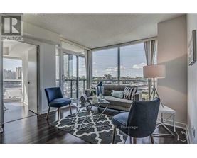 A living room with a view of the cityscape outside the large windows.