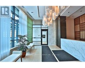 A modern interior space with a reception desk and a potted plant.