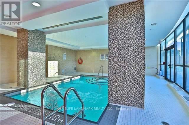A swimming pool inside a building with a glass wall.