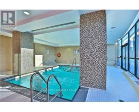 A swimming pool inside a building with a glass wall.