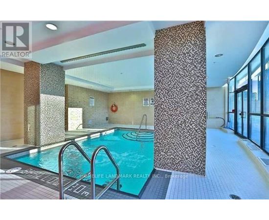 A swimming pool inside a building with a glass wall.