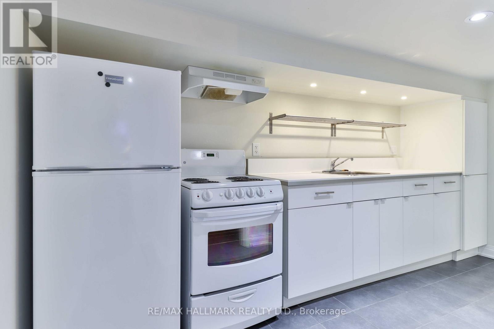 A white kitchen with a refrigerator, oven, and cabinets.