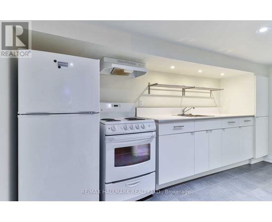 A white kitchen with a refrigerator, oven, and cabinets.
