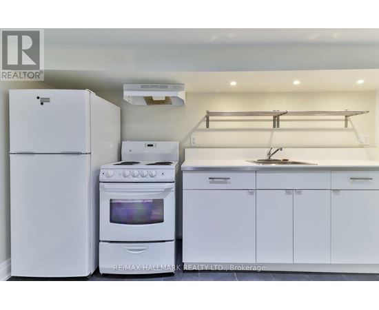 A white kitchen with a refrigerator, oven, and stove.