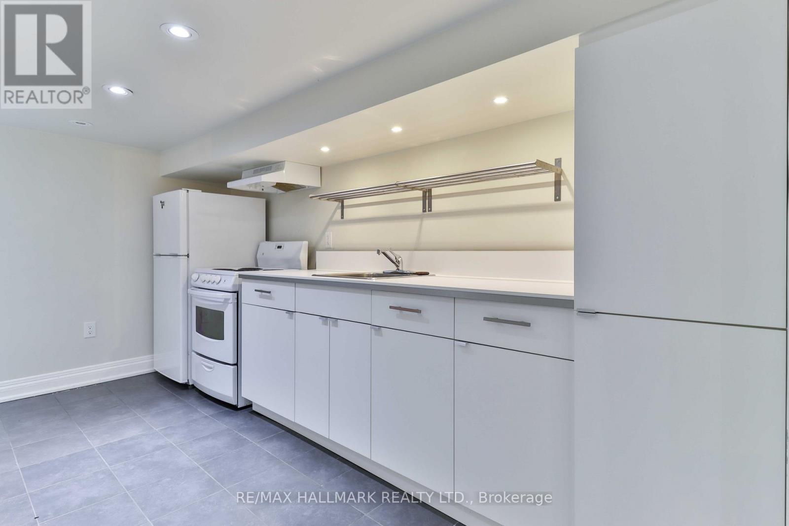 A white kitchen with a refrigerator, oven, and cabinets.