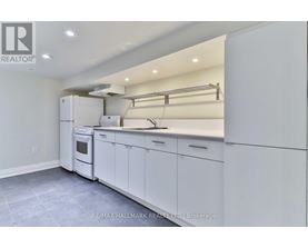 A white kitchen with a refrigerator, oven, and cabinets.