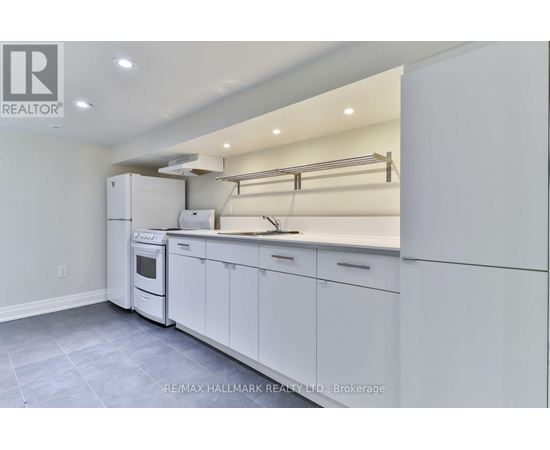 A white kitchen with a refrigerator, oven, and cabinets.