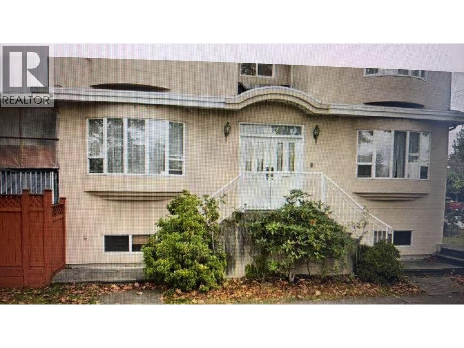 A beige house with a white door and windows.