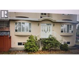 A beige house with a white door and windows.