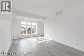 A room with a sliding glass door and wooden flooring.