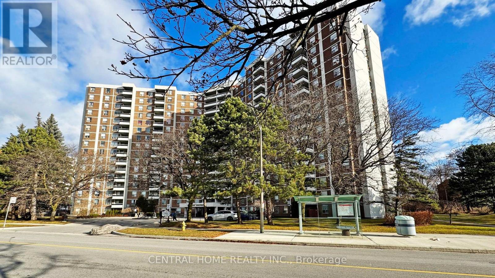A street view of a residential area with apartment buildings and a sign for Central Home Realty Inc.