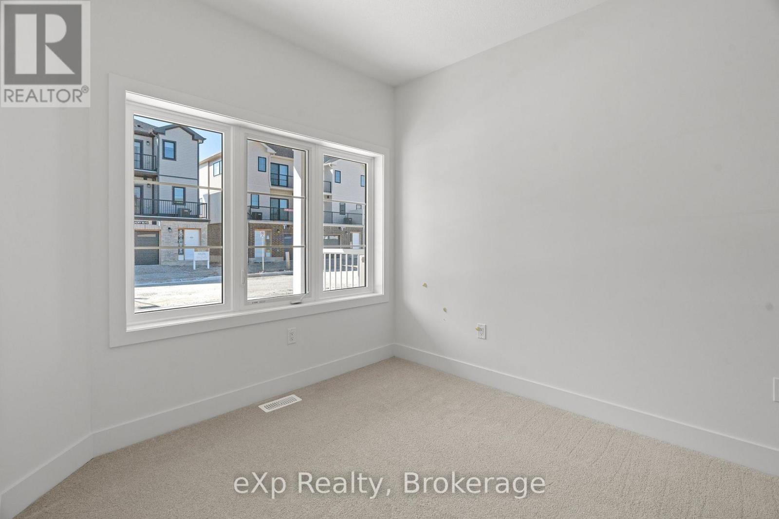 A room with a large window showing a view of a building across the street.