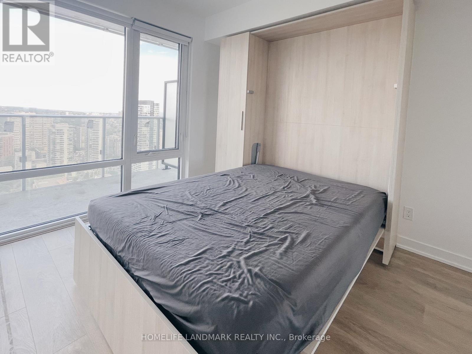A bedroom with a large bed and a view of the city.