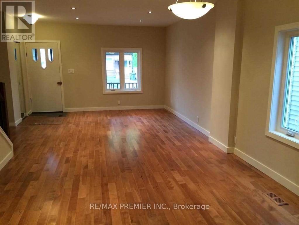 A room with wooden flooring and a window with blinds.