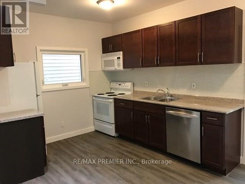 A kitchen with brown cabinets and a white fridge.