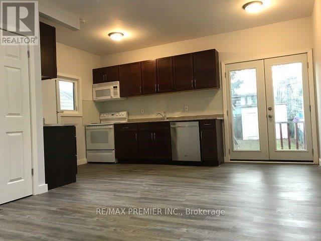A kitchen with dark wood cabinets and a white fridge.