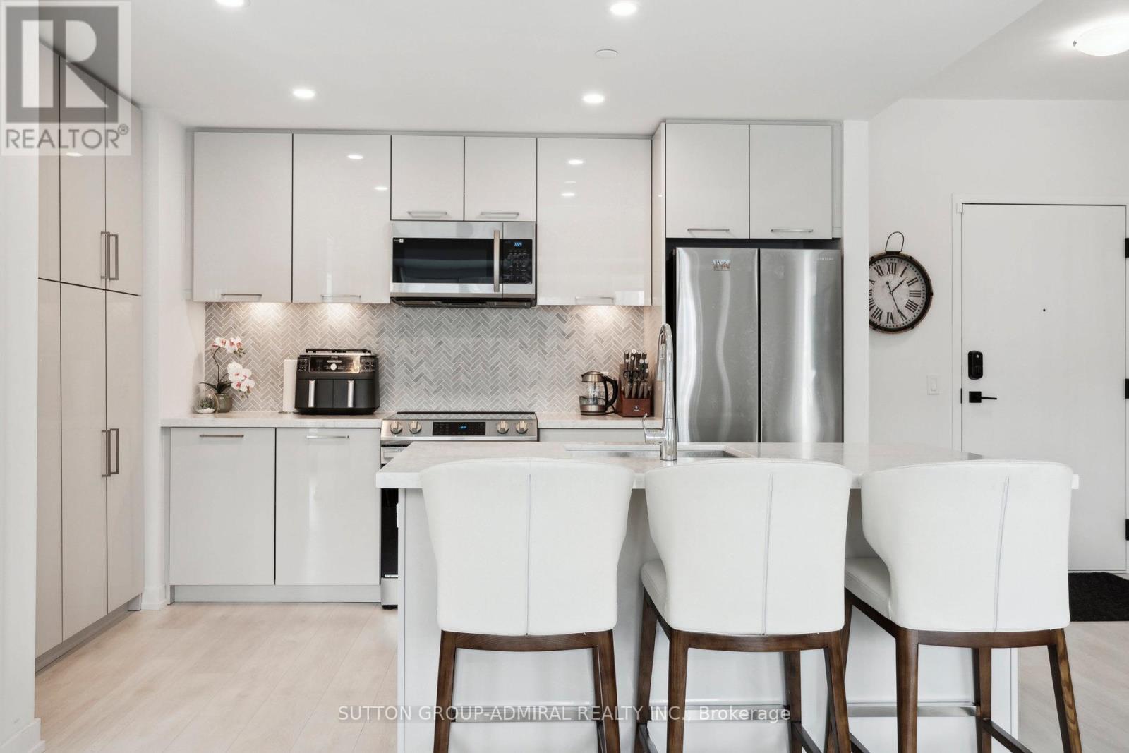 A modern kitchen with white cabinets and appliances.