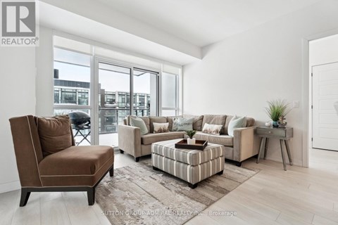 A living room with a brown chair and a striped ottoman.