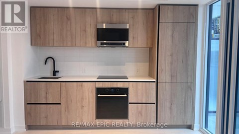 A kitchen with wooden cabinets and a black oven.