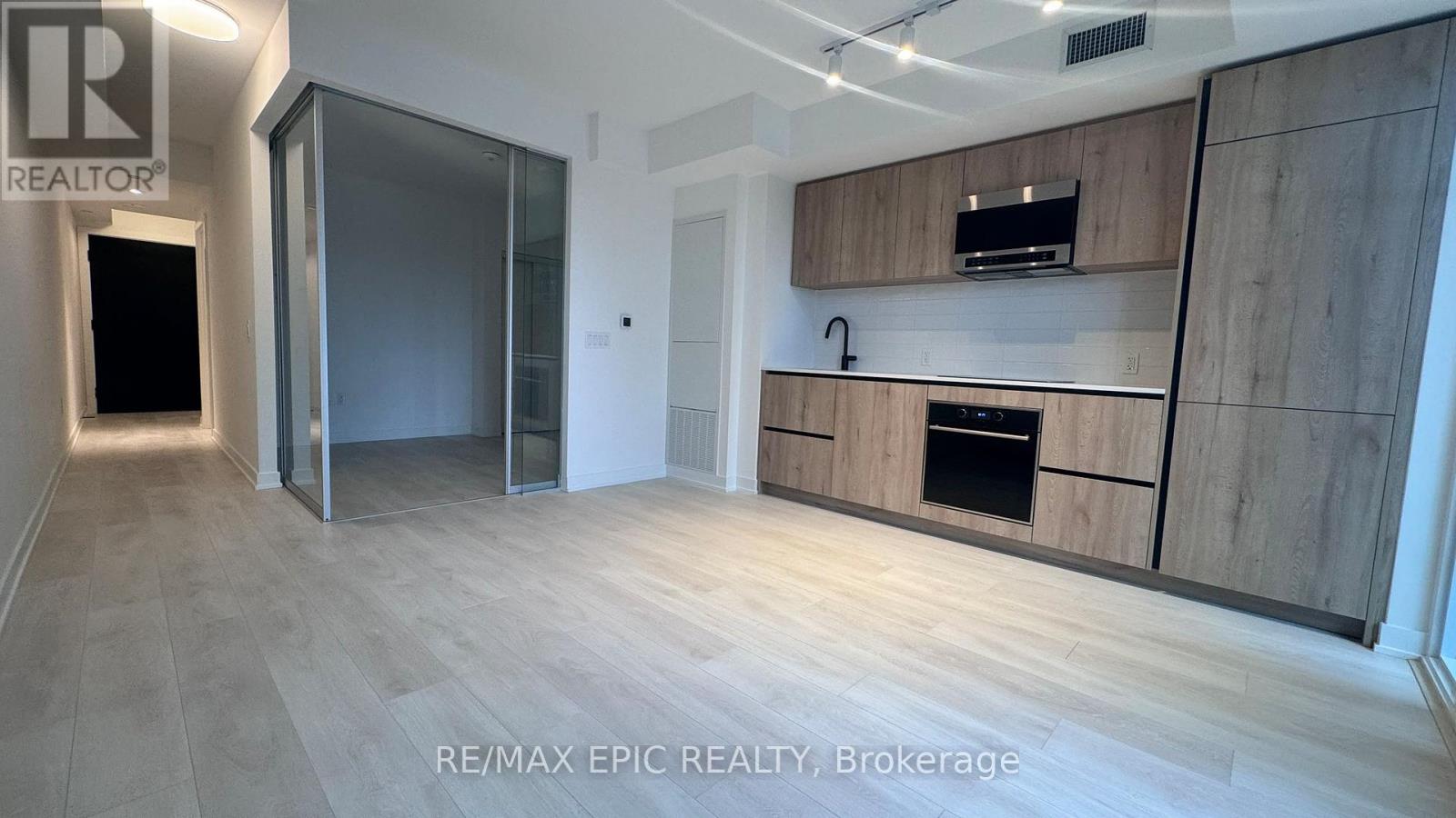 A spacious kitchen with wooden cabinets and a modern design.