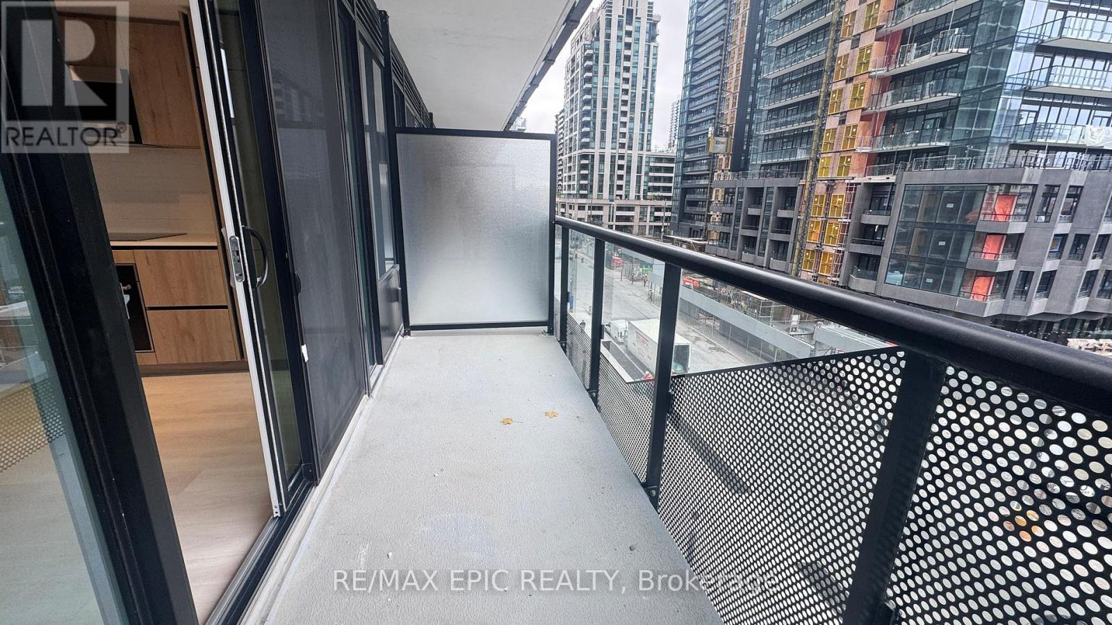 A balcony with a metal railing and glass doors leading to a building.