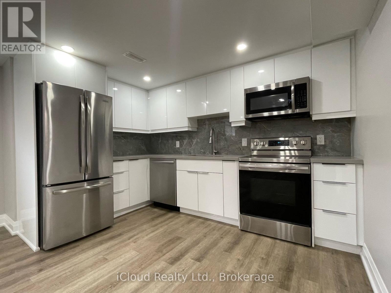 A modern kitchen with stainless steel appliances and white cabinets.