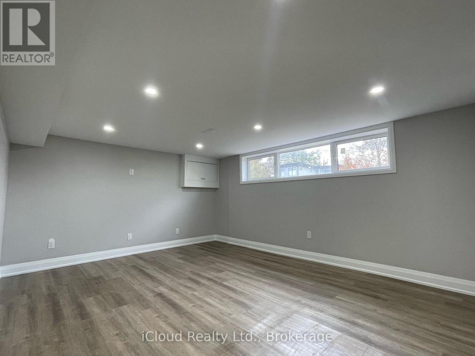 A room with wooden flooring and a window letting in natural light.