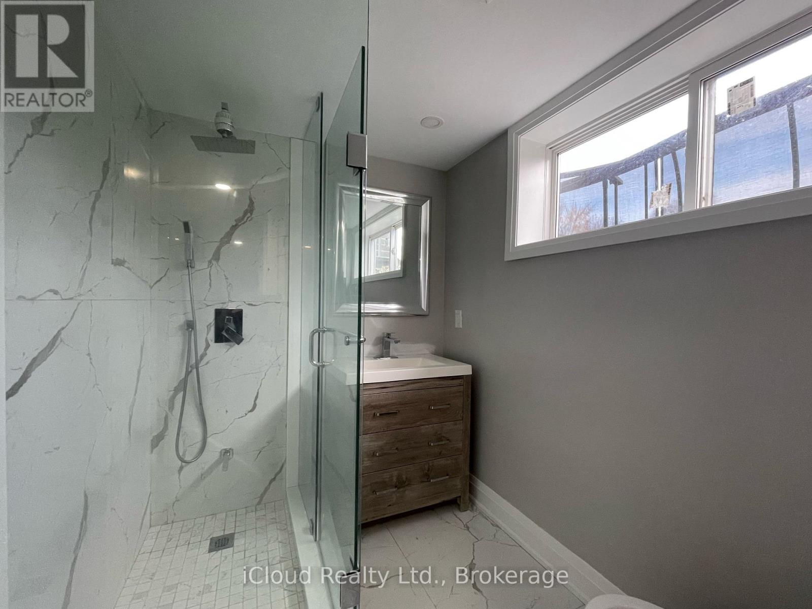 A bathroom with a walk-in shower and a window.