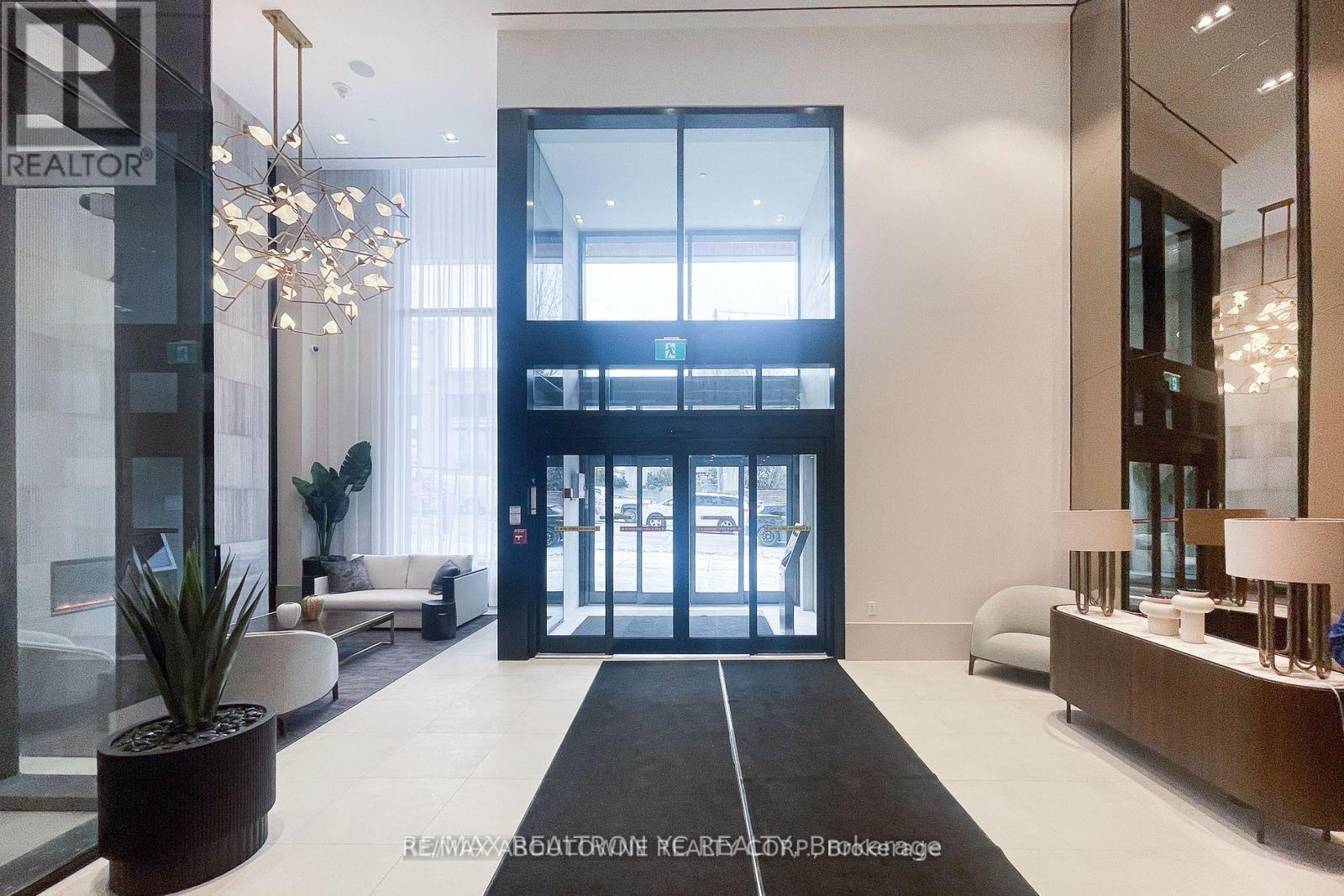 A modern office lobby with a large glass wall and a reception desk.